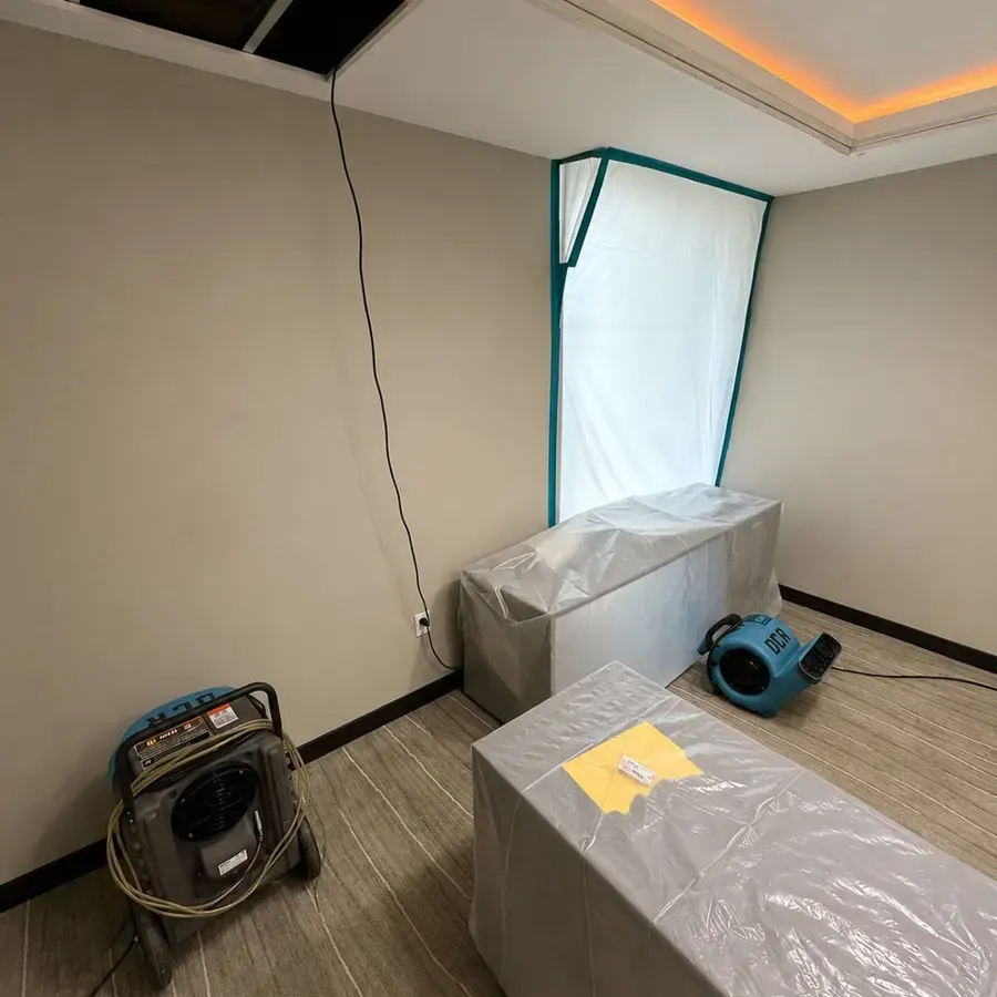 Plastic containment and air movers set up in an emptied room during structural drying