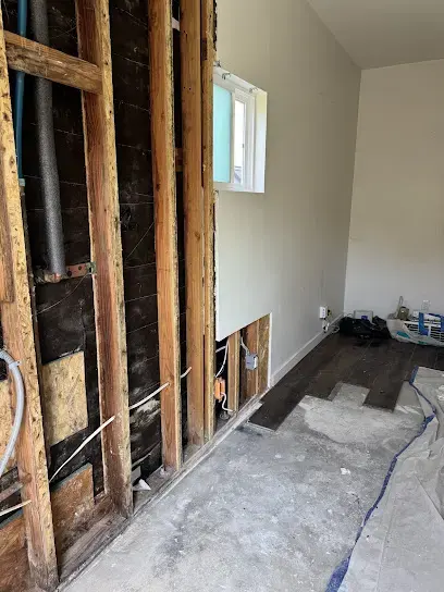 A wall opened to the framing with the floor covering removed during drying