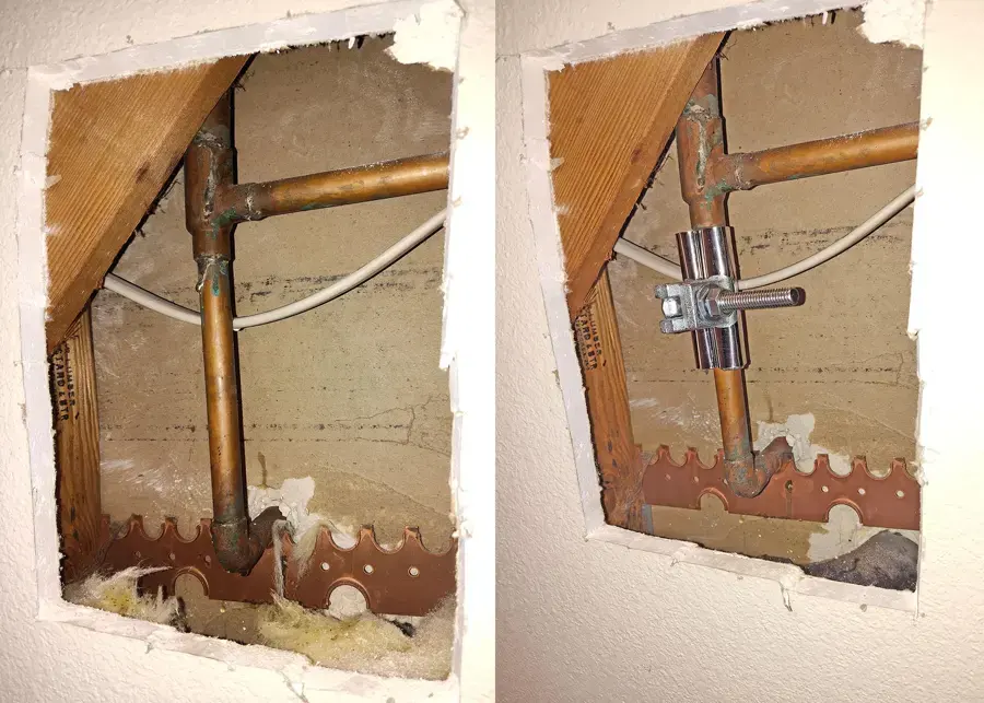 Drywall cut open to expose leaking copper supply pipes inside a wall