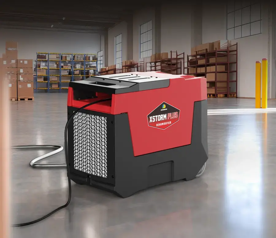 A commercial dehumidifier running on a concrete floor during structural drying